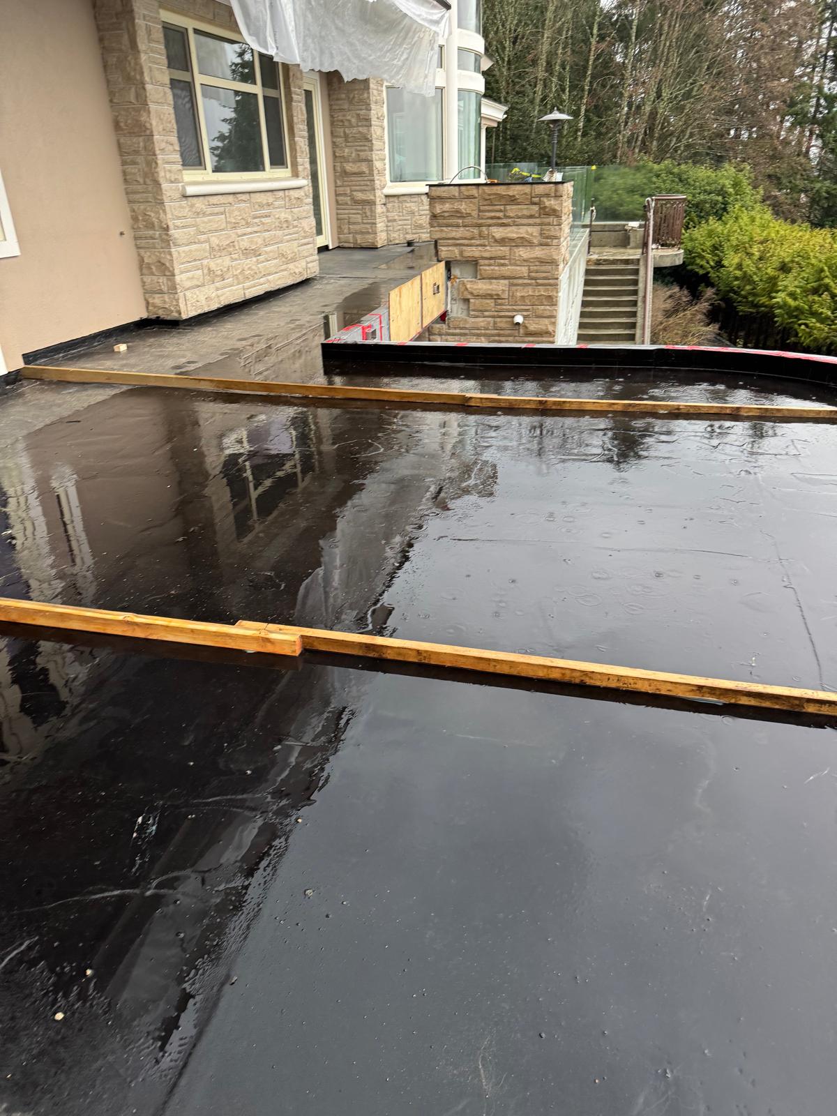 Applier installing high-performance silicone sealant joint around high-rise window perimeter.